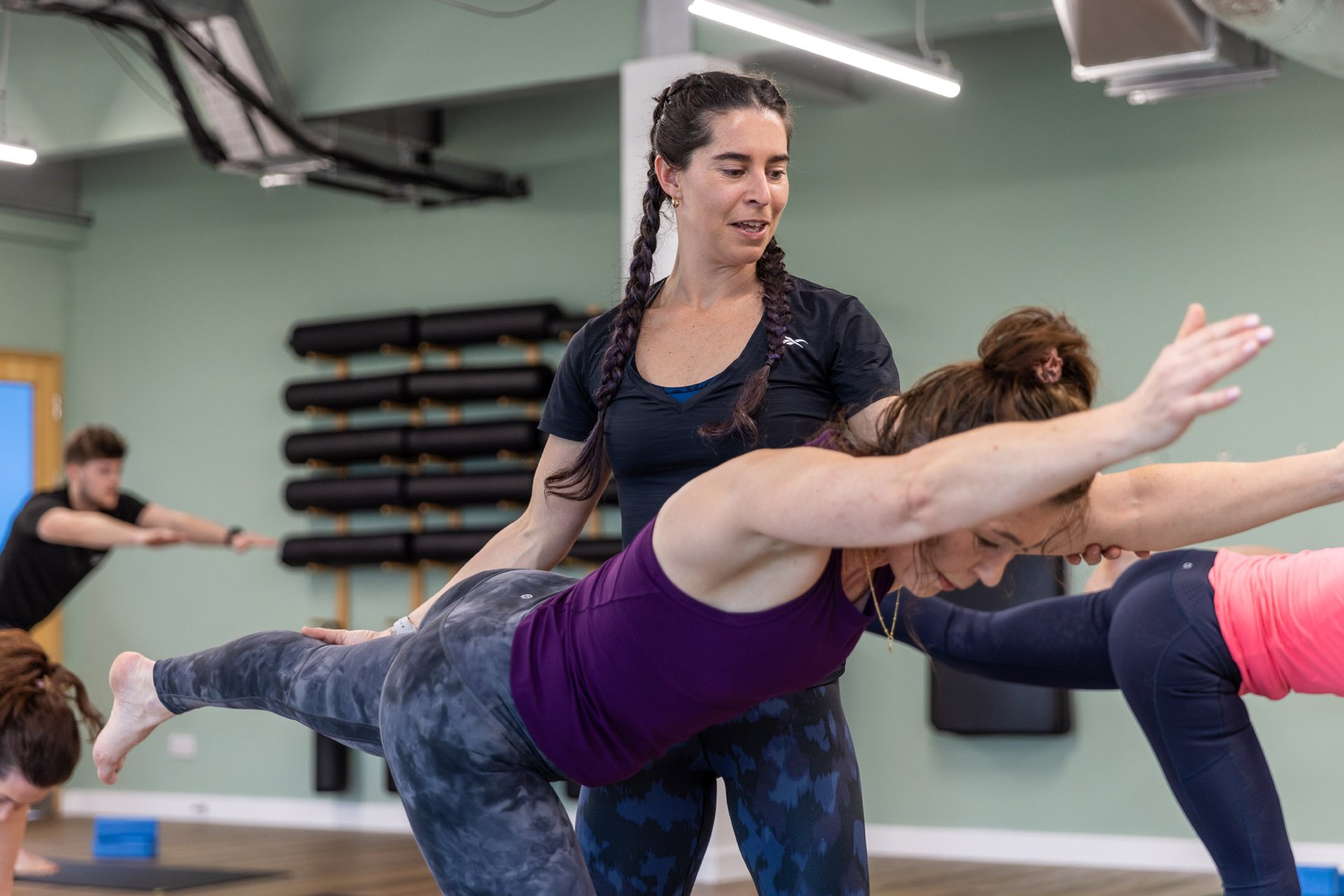 Yoga teacher instructing a member during a class in the Wellness studio at Westwoods Health Club