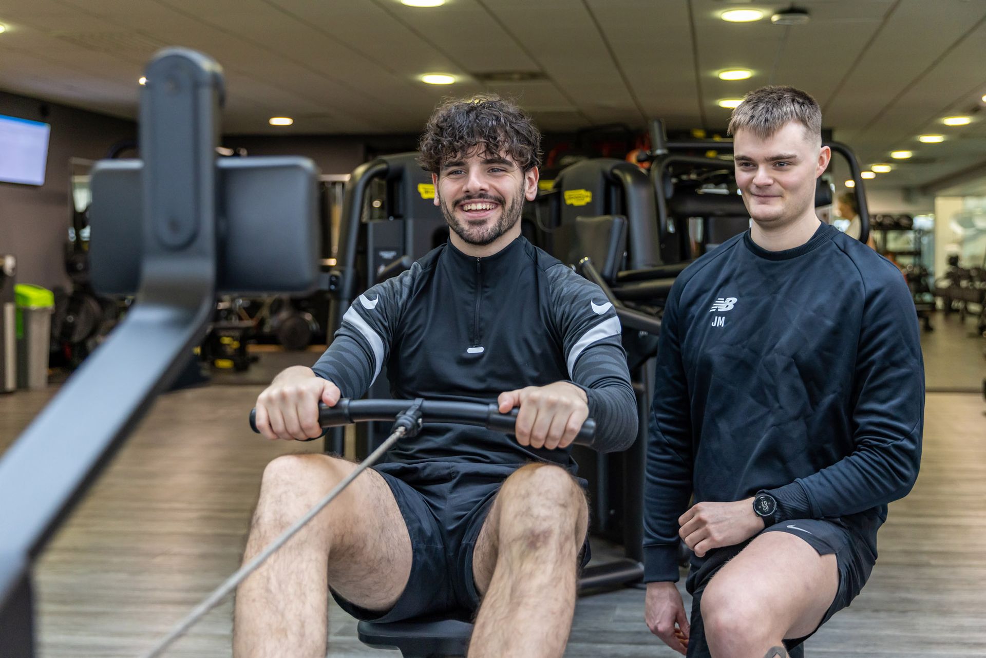 Jack mellor personal trainer at Westwoods Health Club working with a client to on their fitness routine on the lat pulldown weights machine