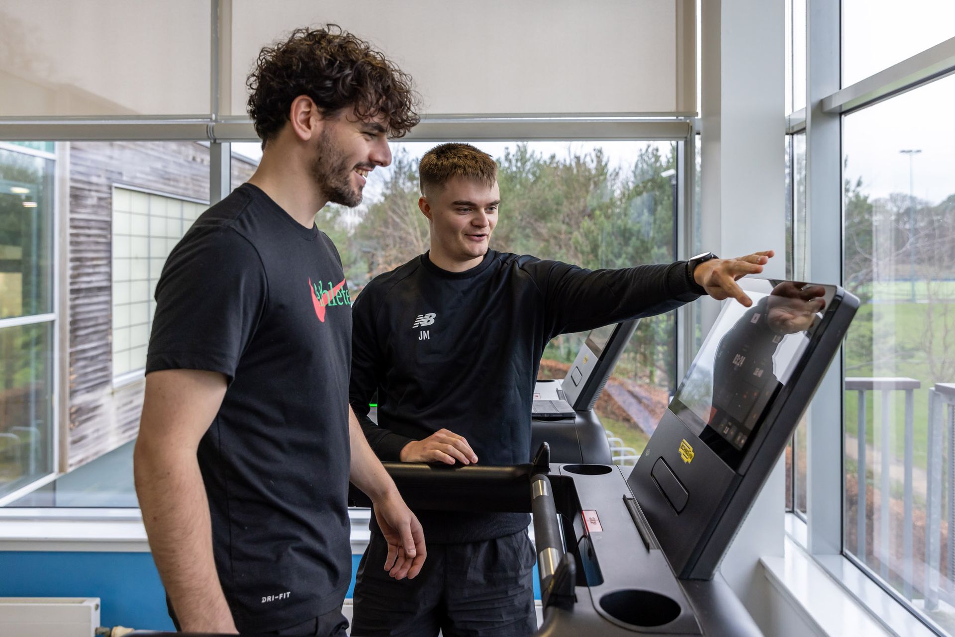 Jack mellor personal trainer at Westwoods Health Club working with a client to on their fitness routine on the lat pulldown weights machine