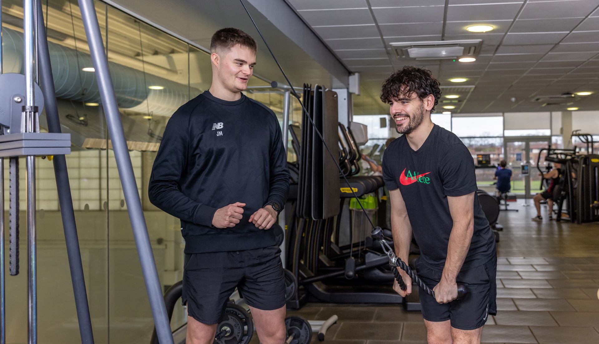 Jack mellor personal trainer at Westwoods Health Club working with a client to on their fitness routine on the lat pulldown weights machine