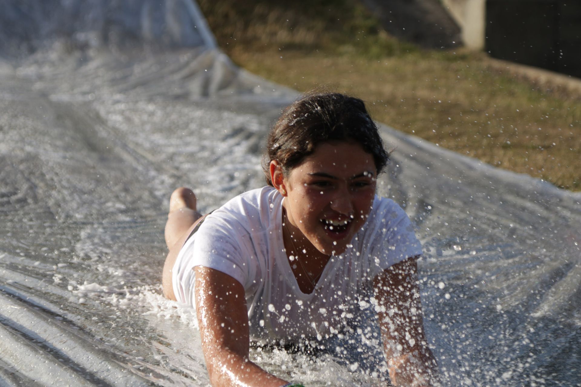 female doing the slip 'n' slide during the Fettes Active multi-activity camp at westwoods health club and fettes college