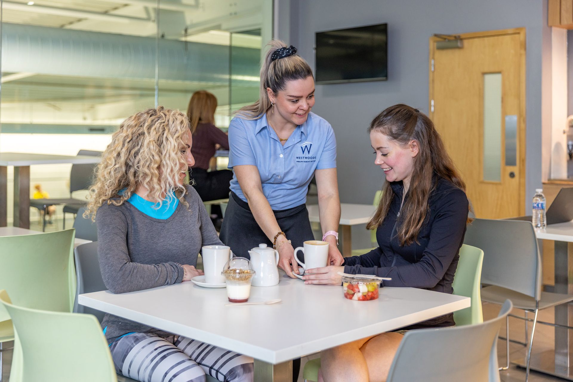 Members of westwoods health club relaxing in café refresh enjoying food and drinks