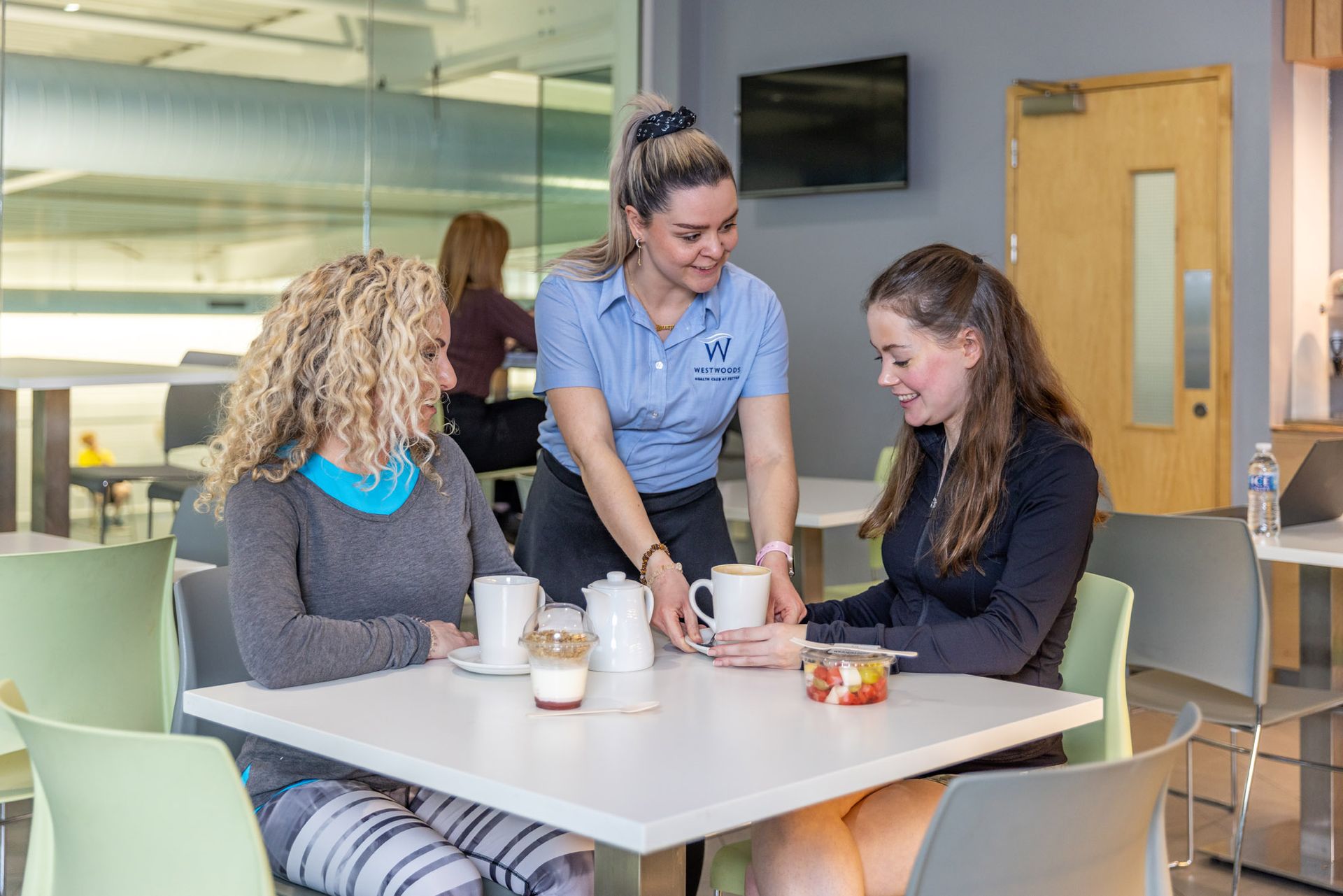 Members of westwoods health club relaxing in café refresh enjoying food and drinks