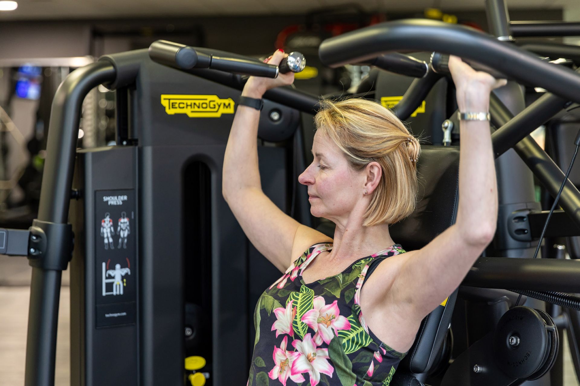 Fenmale member of Westwoods Health Club using the Technogym weights machine in the gym