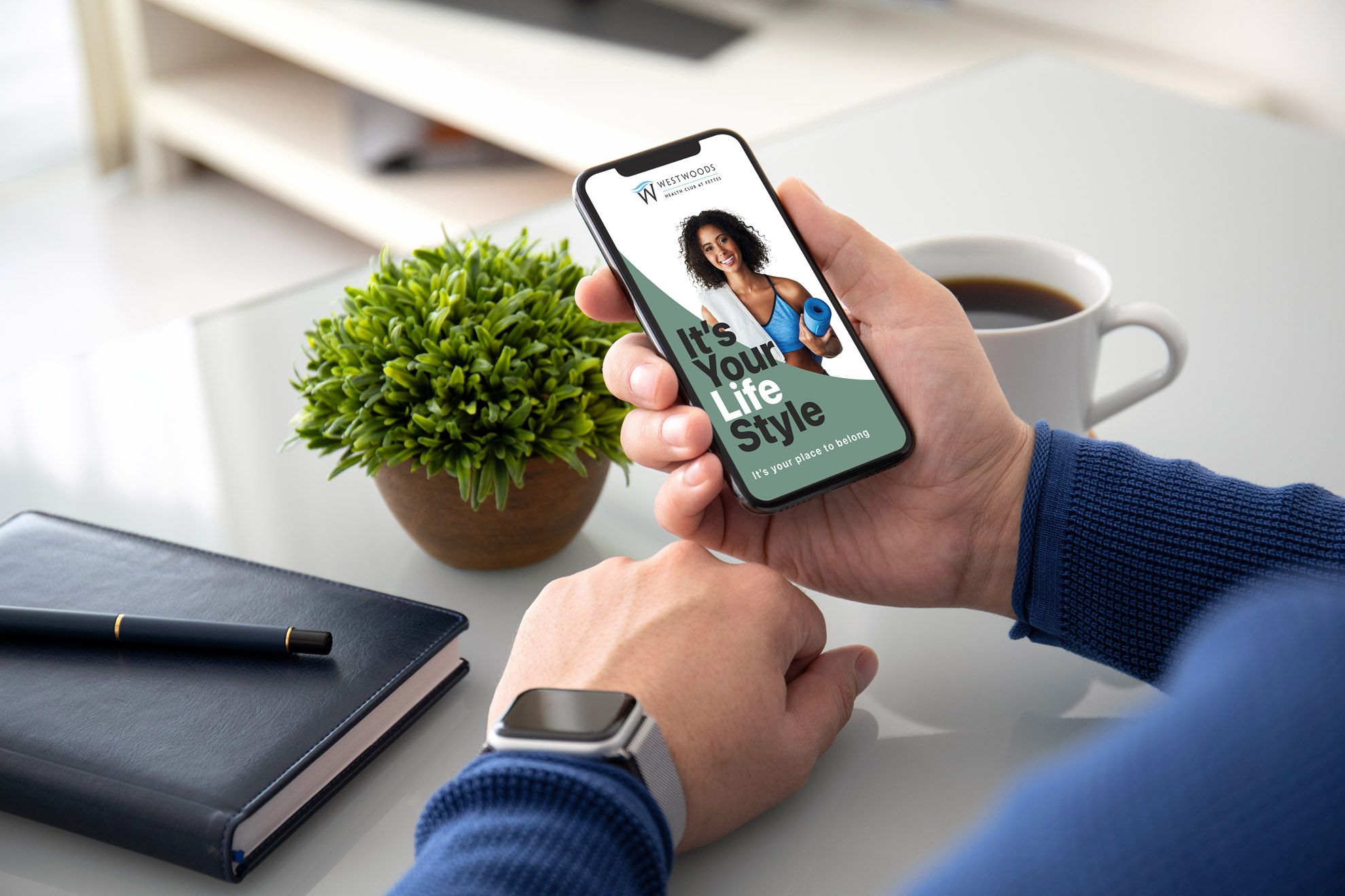 Westwoods member sitting in café refresh using the Westwoods app on their iphone