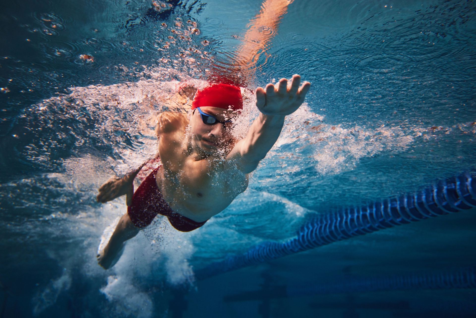 Adult male swimming in pool.